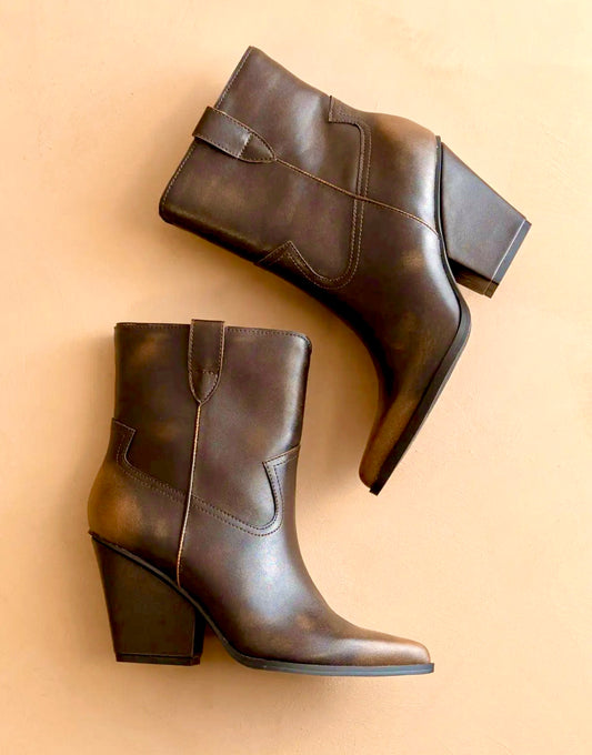 Pair of brown two toned distressed  leather ankle boots on a beige background