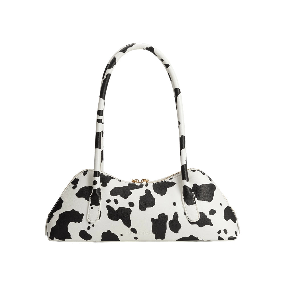 Black and white cow print handbag on a white background