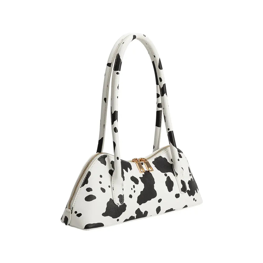 White handbag with black cow print pattern on a white background
