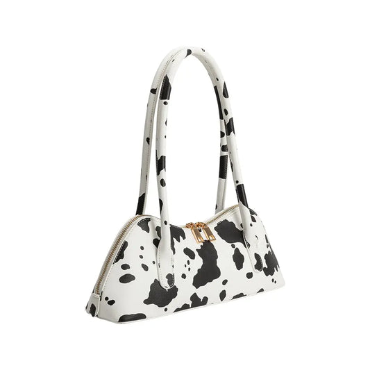 White handbag with black cow print pattern on a white background