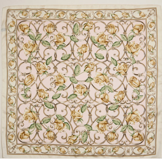 Decorative design on a silky scarf with yellow roses and green leaves on a beige background